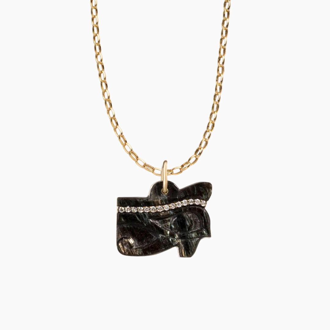 Necklace with a black stone pendant on a gold chain against a white background